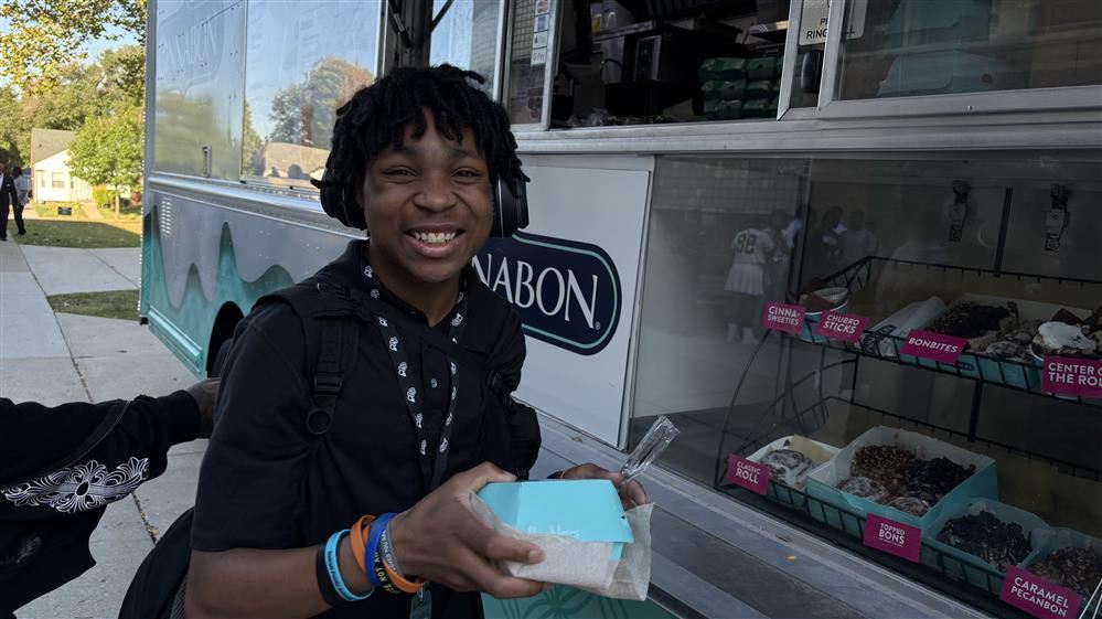  Student holding a Cinnabon outside of truck